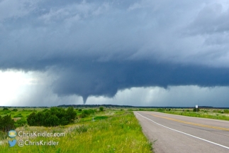 Under a classic wall cloud, the funnel thickened.