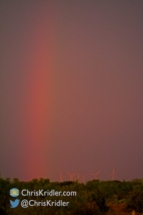 A weak rainbow appeared over the wind turbines.