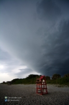 A lonely lifeguard chair is overshadowed by the storm.