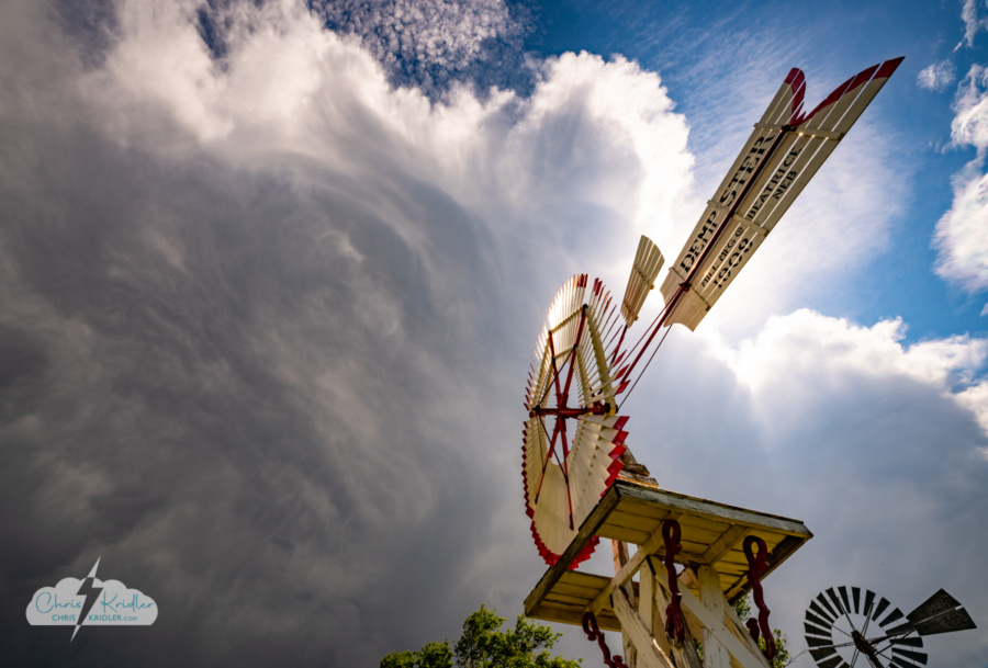 Shattuck windmill park with storm, by Chris Kridler