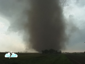 The tornado heads for the road and a house.